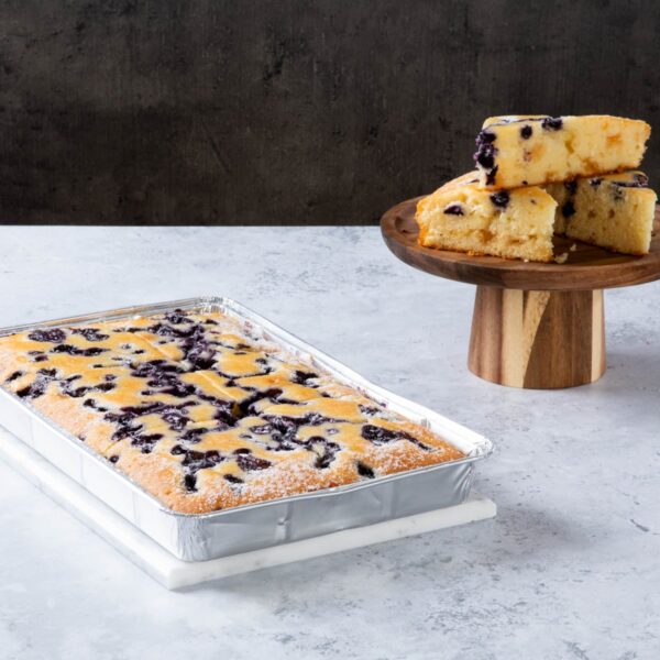 Blueberry crumble cake slices on a wooden cake stand and tray.