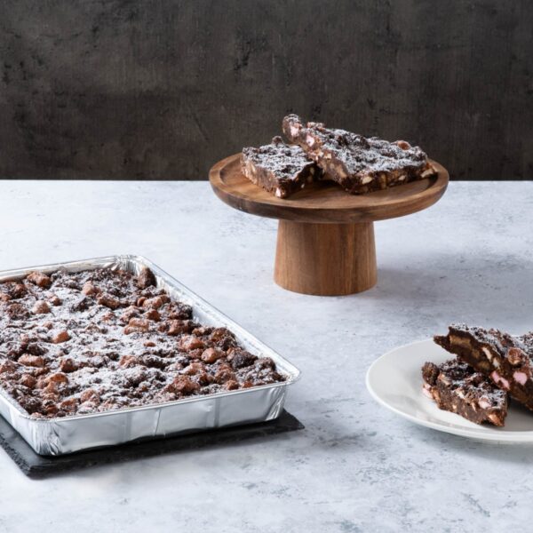 Chocolate rocky road traybake with sliced pieces and icing sugar.
