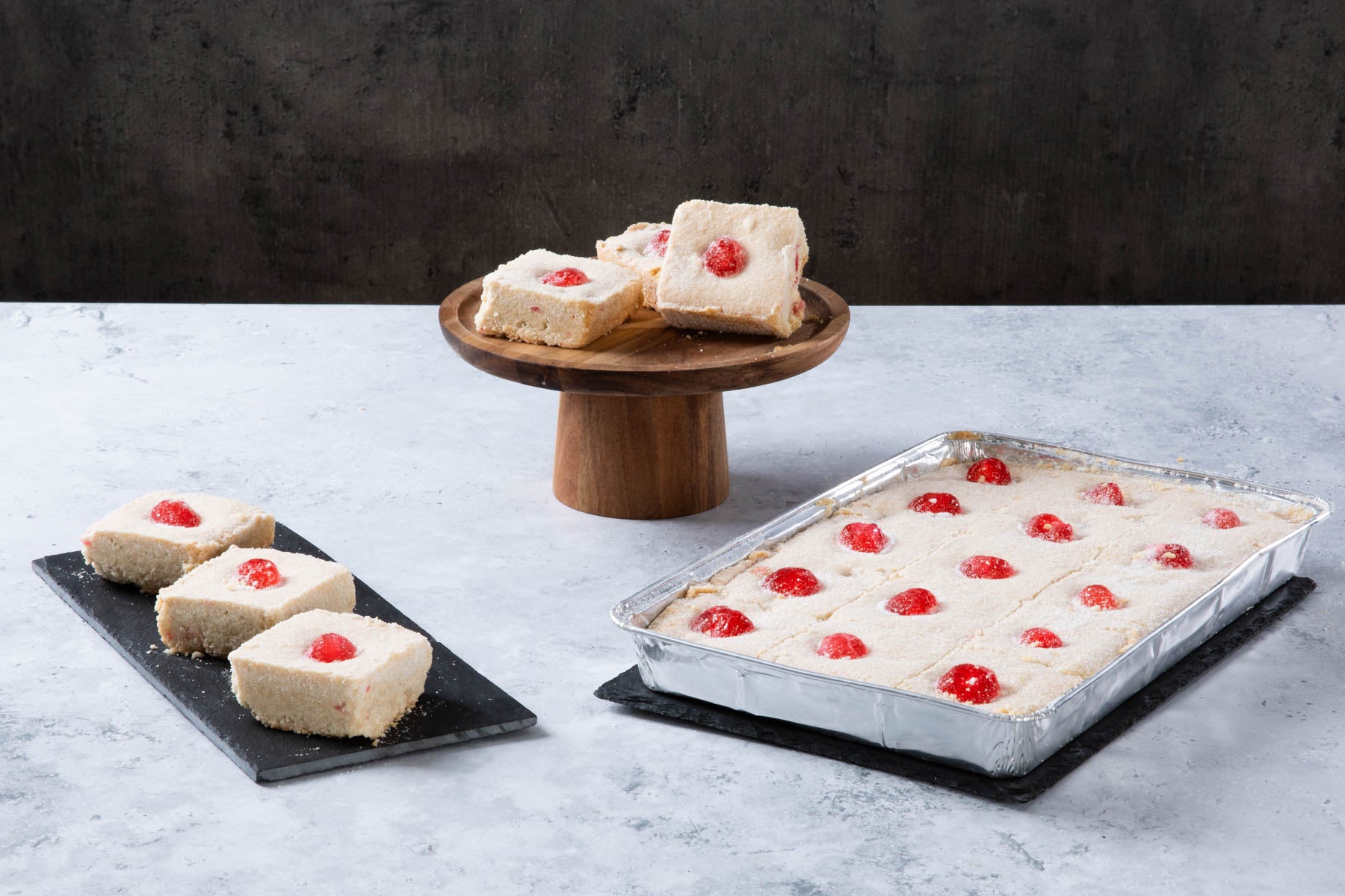 LHMC004-331.jpg Raspberry coconut traybake slices on a wooden cake stand.