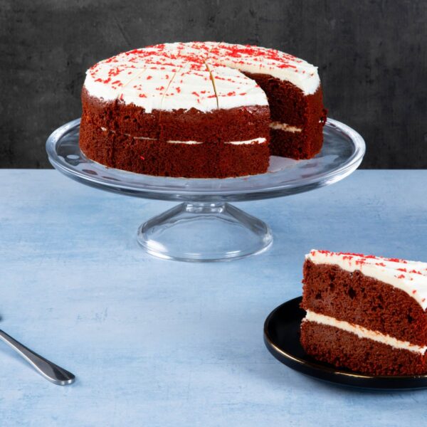 Chocolate cake with chocolate frosting and caramel topping on a wooden board.