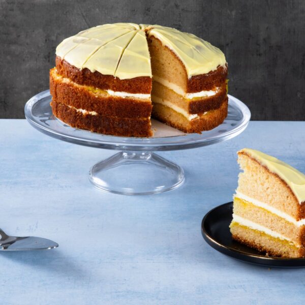 Lemon drizzle cake slices with lemon icing on a wooden board.