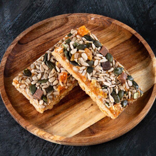 Apricot and seed flapjack slices on a wooden plate.