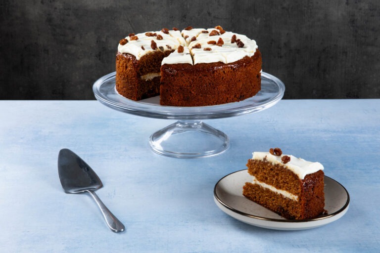 Carrot and sultana gateaux with cream icing and sliced piece.